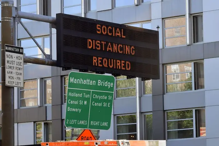 Roadway sign on the Manhattan Bridge stating "Social Distancing Required" in June.